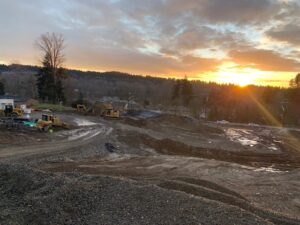 A construction site with an amazing location and a sun setting behind it.