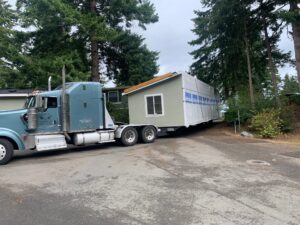 New Homes have begun arriving on a semi truck pulling a trailer.