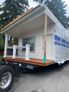 A white trailer with a white house on it is one of the new homes that have begun arriving.