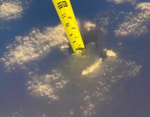 A yellow tape measure is in the middle of the snow, causing delays.