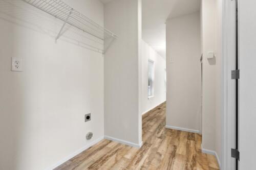 A hallway with hardwood floors and a closet.