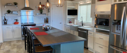 A kitchen with stainless steel appliances and counter tops.