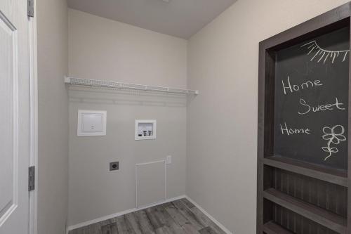 A walk in closet with a chalkboard wall.