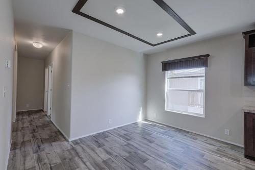 An empty room with wood floors and wood cabinets.