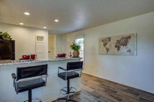 A kitchen with bar stools and a map on the wall.