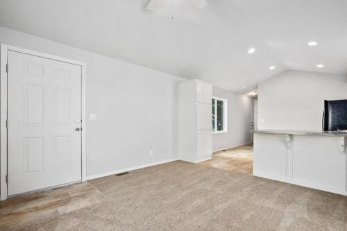 An empty room with white walls and carpet.